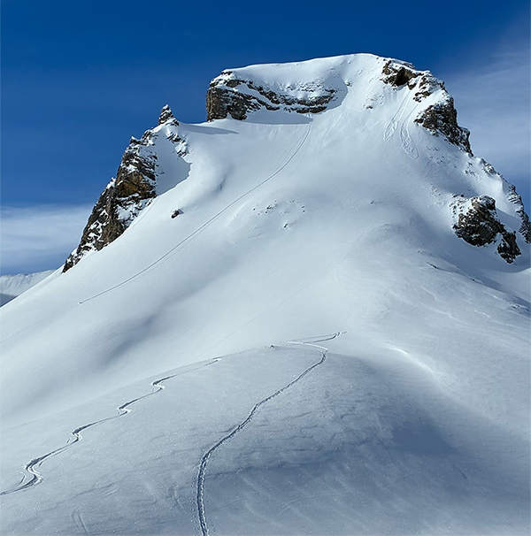 Pendiente nevada bajo un cielo azul